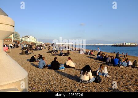 Brighton UK 2 aprile 2021 - i gruppi si riuniscono sulla spiaggia di Brighton nel tardo pomeriggio sole sul Venerdì Santo, ma la previsione è per molto più freddo tempo da Lunedi con la neve prevista per alcune aree del Regno Unito: Credit Simon Dack / Alamy Live News Foto Stock