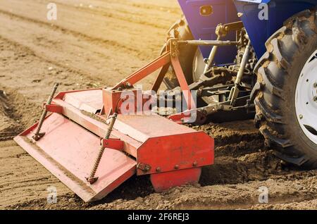 Il trattore con fresatrice allenta, macina e mescola il terreno. Allentare la superficie, coltivando il terreno per piantare ulteriormente. Agricoltura e agricoltura Foto Stock
