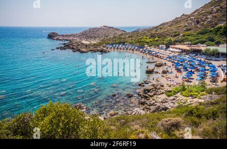 Bellissima spiaggia della baia di Ladiko con acque blu limpide vicino a Faliraki, isola di Rodi, Grecia in una giornata estiva soleggiata. Foto Stock