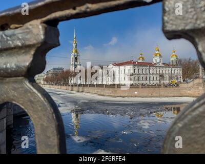 Russia, San Pietroburgo, 02 aprile 2021: San Nicola Naval Cathedral Campanile attraverso il reticolo forgiato in un chiaro giorno di sole di primavera, una deriva di ghiaccio Foto Stock