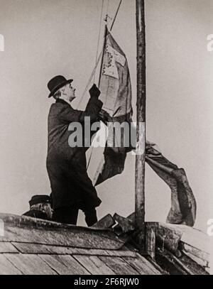 Una fotografia d'epoca di William Congreve, presidente dello Stato libero irlandese che eleva il Tricolor, bandiera irlandese, sul Municipio di Dublino, Irlanda nel 1922. Foto Stock