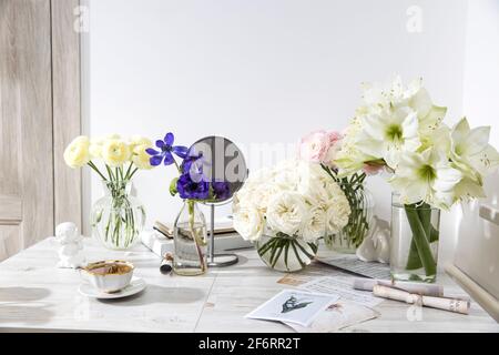 Londra, Regno Unito - 20 marzo 2021, rose bianche, ranuncolo rosa, anemoni blu, coppe giallastre, gigli in vasi rotondi sul tavolo per un'occasione speciale Foto Stock