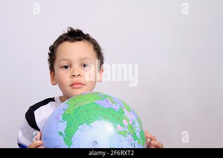 ragazzo con globo che guarda in su sulla foto di scorta bianca di sfondo Foto Stock