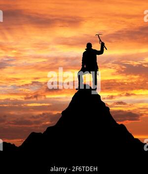 Silhouette da sera - vista dell'uomo sulle montagne con ghiaccio ax in mano sulla silhouette del monte ama dablam Foto Stock