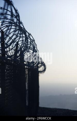 immagine verticale della recinzione del filo del rasoio con messa a fuoco selettiva Foto Stock