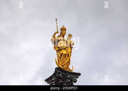 Statua dorata della Vergine Maria in cima al Mariensäule, la colonna mariana situata sulla Marienplatz a Monaco di Baviera, Germania Foto Stock