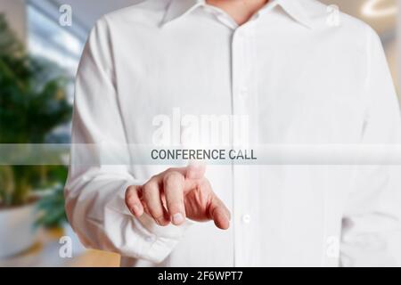 L'uomo d'affari preme il pulsante di chiamata in conferenza su uno schermo virtuale. Creazione di un concetto di chiamata in conferenza online. Foto Stock