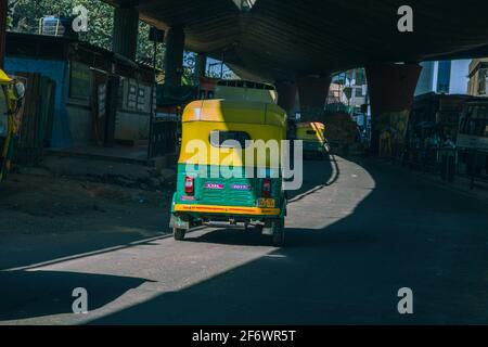 K.R.Market, Bangalore, India - Febbraio 06,2021: Corsa in tuk-tuk nella città di bangalore sotto il ponte in krmarket Foto Stock