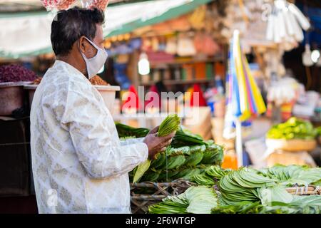 K.R.Market, Bangalore, India - Febbraio 06,2021: Il venditore di foglie di betel contando le foglie sulle strade Foto Stock