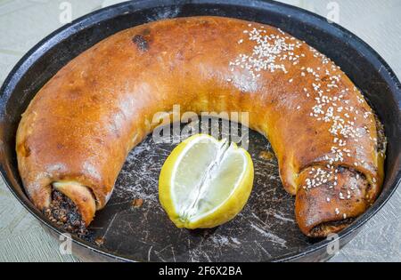 Primo piano torta fatta in casa con marmellata di prugne cotta in un padella con succo di limone Foto Stock