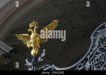 Un'aquila imperiale russa d'oro in cima alle porte in ferro battuto all'ingresso del Palazzo d'Inverno, San Pietroburgo, Russia. Foto Stock