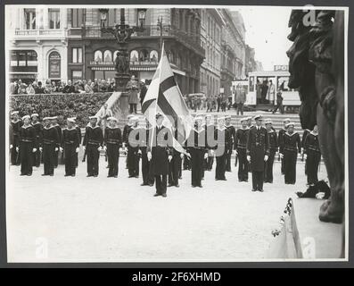 L'immagine mostra una parata militare di soldati marini in formaggio marinaio, probabilmente in Francia.l'ufficiale di fronte alla messa a punto presenta una bandiera di guerra con croce scandinava.sullo sfondo, una strada metropolitana è visibile con la fine del secolo e tram.sulla sinistra, è stato raccolto un piccolo pubblico. L'immagine mostra una parata militare navetta di soldati marini in costo marinaio, probabilmente in Francia.l'ufficiale di fronte alla messa a punto presentare una bandiera di guerra con croce scandinava.sullo sfondo, una strada metropolitana è visibile con la fine del secolo e tram. Sulla sinistra s Foto Stock