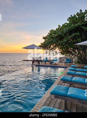 Rilassante spiaggia estiva, solarium e piscina privata con palme vicino alla spiaggia e vista panoramica sul mare presso la casa di lusso Curacao Caribbean Foto Stock