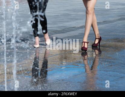 Primo piano di due gambe di donne che camminano in strada, Malta Foto Stock