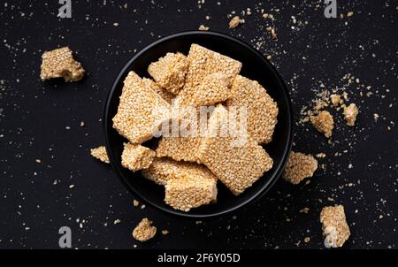 Sesamo kozinaki su sfondo nero, vista dall'alto Foto Stock