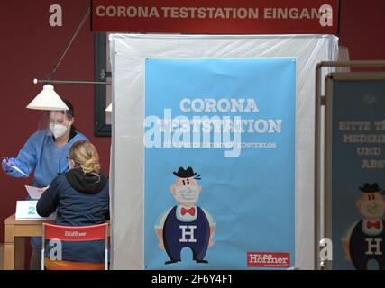 03 aprile 2021, Brandeburgo, Schönefeld: Una giovane donna viene informata della procedura di prova corona da un dipendente della Blaschek Medical Distribution (BMD) presso la stazione di prova corona del negozio di mobili Möbel-Höffner. Nel negozio di mobili, i clienti possono avere essi stessi testato per il virus Corona gratuitamente prima di fare acquisti come parte dei cosiddetti test Citizen. Foto: Soeren Stache/dpa-Zentralbild/dpa Foto Stock