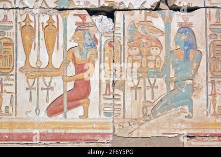 Un'antica scultura geroglifica egiziana che mostra due sacerdotesse che portano offerte di vino e cibo per gli dei. Tempio di Ramses, Abydos, Egitto. Foto Stock