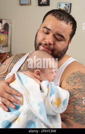 Neonato bambino ragazzo 7 settimane di sonno tenuto da padre Foto Stock