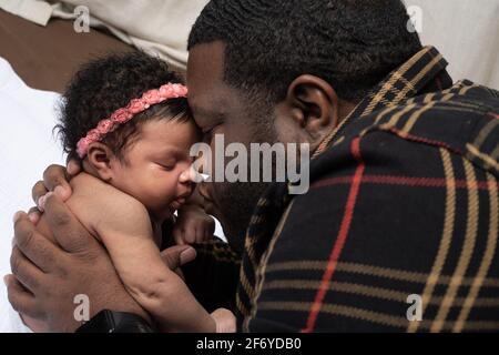 Bambina neonato di 3 settimane, tenuta dal padre Foto Stock