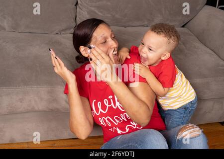 Madre che interagisce e gioca con il figlio di 2 anni, nascondersi e cercare in vista normale Foto Stock