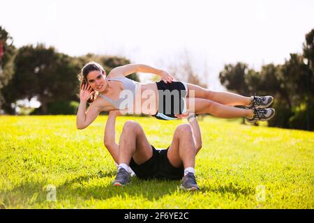 Coppia che fa esercizi acrobatici nel parco cittadino Foto Stock