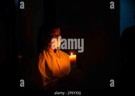 Soppeng, Indonesia. 03 Apr 2021. Uno dei cattolici adorano la notte quaresimale nella Chiesa di nostra Signora. La popolazione cristiana in Indonesia è di circa il 10%, mentre i cattolici rappresentano circa il 3.3% della maggior parte dei musulmani in Indonesia. Il processo di culto si è svolto sotto la pesante guardia della polizia e dell'esercito. La guardia è stata condotta perché ci sono stati atti di terrore a Makassar e la polizia nazionale di Giacarta. (Foto di Moch Farabi Wardana /Pacific Press) Credit: Pacific Press Media Production Corp./Alamy Live News Foto Stock