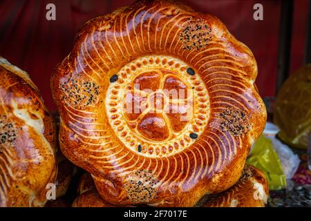 Il pane tradizionale kirghiso viene venduto nel mercato OSH, in Kirghizistan. Cucinato comunemente su un tandoor ed è quindi condito per generare un pane delizioso e spesso. Foto Stock