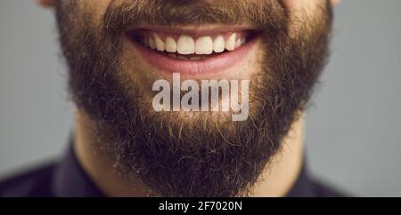 Uomo sicuro bearded bianco sorriso toothy primo piano su faccia studio verticale Foto Stock