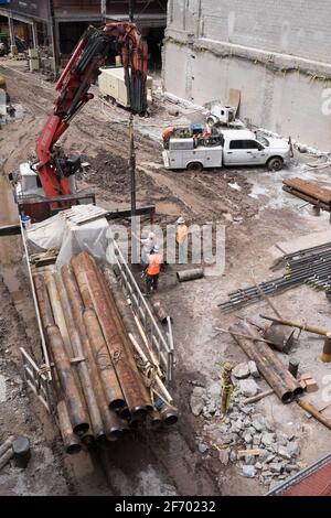 Cantiere a New York con macchine industriali pesanti, camion, gru e persone Foto Stock