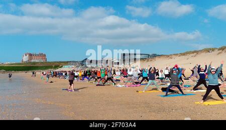 Newquay, Cornovaglia, Inghilterra, 3 aprile 2021. Tempo nel Regno Unito: Rinfrescati con il sole per una lezione di yoga di massa che coinvolge più di 300 partecipanti. Discoteca silenziosa yoga organizzato da Anthony Durkin DJ in combinazione con Oceanflow yoga. Spiaggia di Fistral. Credit: Robert Taylor/Alamy Live News Foto Stock