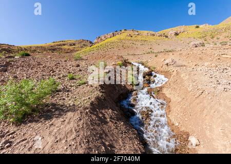 Un rapido torrente di montagna scorre da una piccola montagna vicino a Gahar, Iran Foto Stock