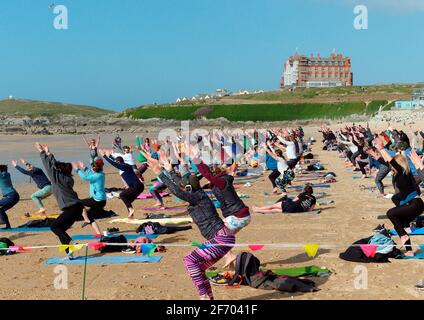 Newquay, Cornovaglia, Inghilterra, 3 aprile 2021. Tempo nel Regno Unito: Rinfrescati con il sole per una lezione di yoga di massa che coinvolge più di 300 partecipanti. Discoteca silenziosa yoga organizzato da Anthony Durkin DJ in combinazione con Oceanflow yoga. Spiaggia di Fistral. Credit: Robert Taylor/Alamy Live News Foto Stock