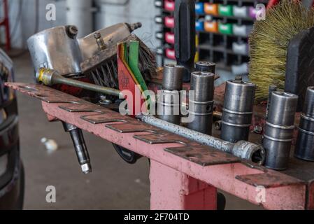 Chiave a percussione e bussole affidabili e resistenti all'intemperie per l'uso nel garage meccanico dell'auto. Foto Stock