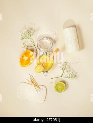 Eco-friendly, composizione cosmetica di scrub agli agrumi, arancio, laim e accessori da bagno naturali su sfondo chiaro. Benessere, cura della pelle e spa Foto Stock