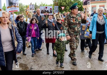 Kerch, Russia 05 09 2019 : Festa della Vittoria della Parata. La gente partecipa all'azione patriottica Reggimento immortale. Stanno tenendo ritratti di persone che Foto Stock