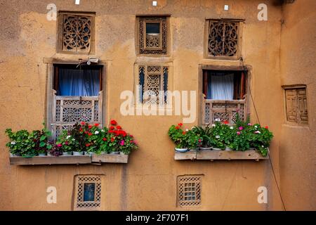 Vista esterna di finestre rustiche con fiori appesi all'esterno dell'edificio nel villaggio di Masuleh, provincia di Gilan, Iran Foto Stock