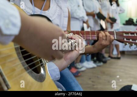 Due studenti che suonano chitarre acustiche in una celebrazione al scuola Foto Stock