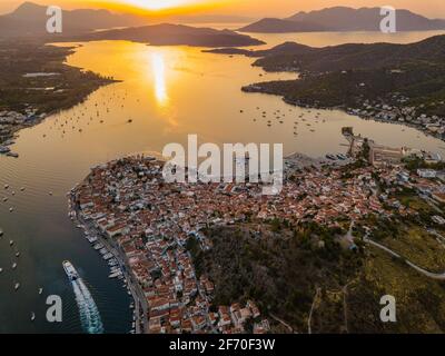 Vista aerea della chiesa di montagna Kastro e della città sull'isola di Poros durante il tramonto. Grecia in estate Foto Stock