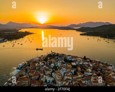 Vista aerea della chiesa di montagna Kastro e della città sull'isola di Poros durante il tramonto. Grecia in estate Foto Stock