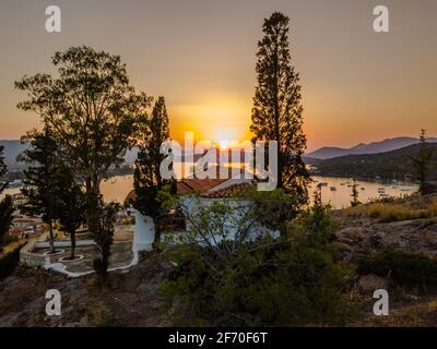 Vista aerea della chiesa di montagna Kastro e della città sull'isola di Poros durante il tramonto. Grecia in estate Foto Stock