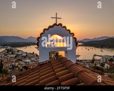 Vista aerea della chiesa di montagna Kastro e della città sull'isola di Poros durante il tramonto. Grecia in estate Foto Stock