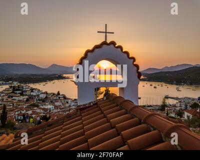 Vista aerea della chiesa di montagna Kastro e della città sull'isola di Poros durante il tramonto. Grecia in estate Foto Stock