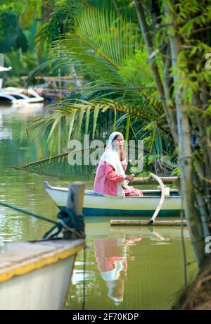 Filipina boatwoman in una piccola canoa di Outrigger. Fiume Loboc, Bohol, le Filippine. Foto Stock