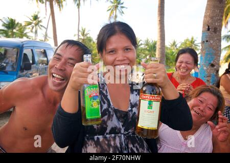 Famiglia e amici filippini che si godono la spiaggia insieme e un paio di bevande. Santa Fe, Isola di Bantayan, Cebu, Filippine Foto Stock