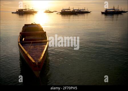 Barca ormeggiata al largo di Logon, Malapascua Island al tramonto. Mare di Visayan, Cebu, Filippine. Foto Stock
