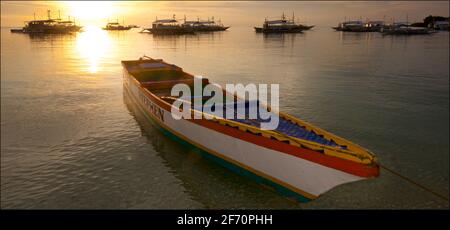 Barca ormeggiata al largo di Logon, Malapascua Island al tramonto. Mare di Visayan, Cebu, Filippine. Foto Stock