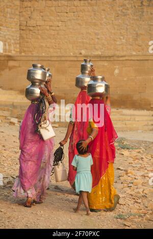 Rajasthani le donne che trasportano l'acqua da un pozzo ad Amar Sagar, Lodurva, nr Jaisalmer, Rajasthan, India Foto Stock