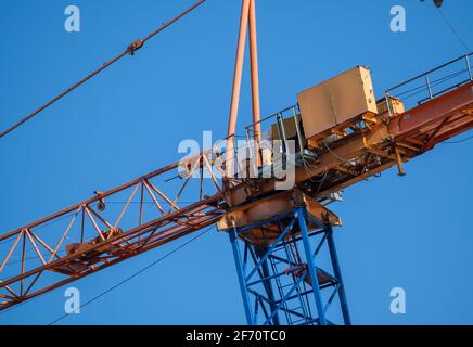 Da sotto frammento di gru industriale ad alto metallo in costruzione sito contro il cielo blu senza nuvole Foto Stock