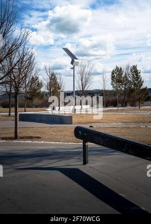 Una lampada a energia solare si ricarica al sole in un parco pubblico di skateboard in Airdrie Alberta Canada. Foto Stock