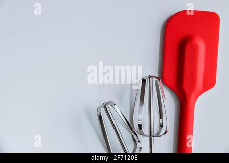 Fornitura di cottura su sfondo bianco. Spatola, mixer sbatte su sfondo bianco Foto Stock